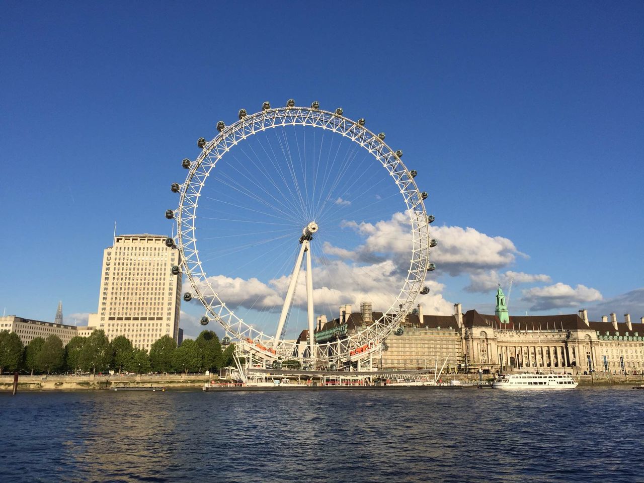 architecture, built structure, ferris wheel, waterfront, water, building exterior, amusement park ride, river, amusement park, arts culture and entertainment, city, travel destinations, sky, famous place, tourism, blue, clear sky, capital cities, international landmark, travel