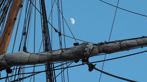Low angle view of sailboat against clear blue sky