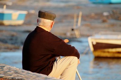 Rear view of man sitting on boat