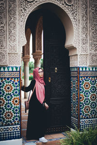 Woman standing by door of building