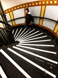 Full length portrait of young man standing on staircase