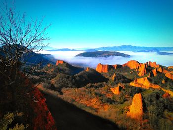 Scenic view of landscape and mountains against blue sky