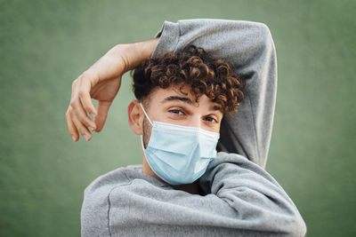 Portrait of man wearing mask against gray background