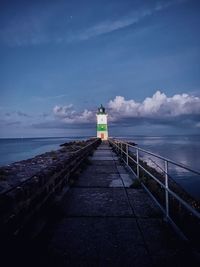 Lighthouse by sea against sky