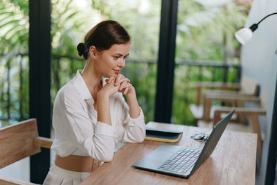 Young woman using laptop at table