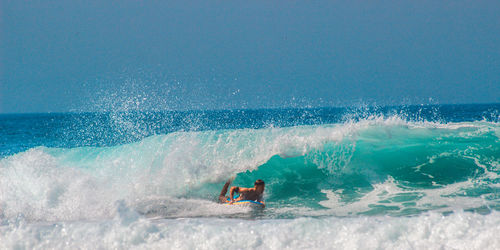 Man surfing in sea against sky