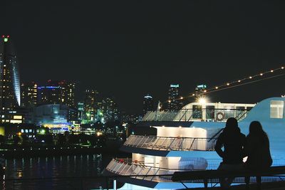 Rear view of woman sitting at night