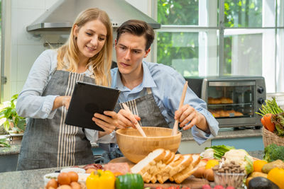 Woman holding food on table at home