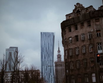 Low angle view of buildings against cloudy sky