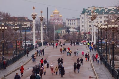 High angle view of people walking on street in city at dusk