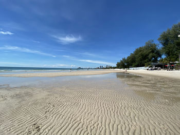 Scenic view of beach against blue sky