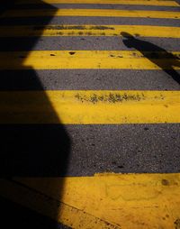 High angle view of yellow shadow on road