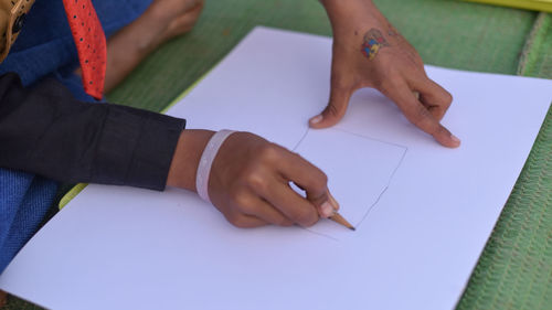 Close-up of boy playing with book on table