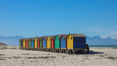 Beach huts at sea shore against sky