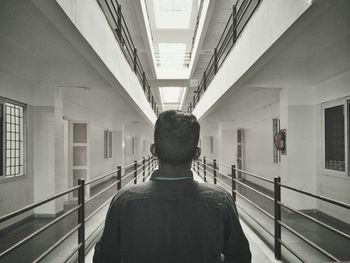 Rear view of man standing in prison