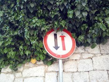 Road sign by wall