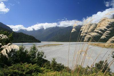 Scenic view of calm sea against mountain range