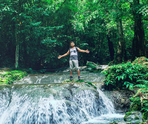 Full length of man on waterfall in forest