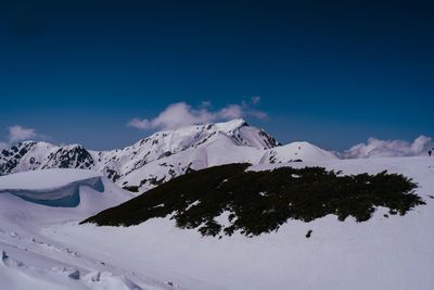 Scenic view of snowcapped mountains against clear blue sky