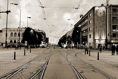 Railroad tracks in city against sky