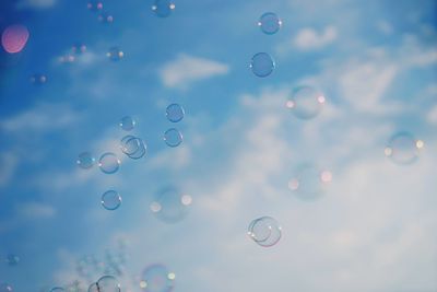 Low angle view of bubbles against sky