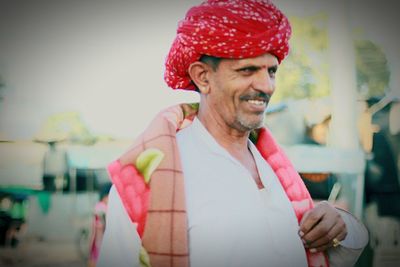 Close-up of smiling man holding red umbrella