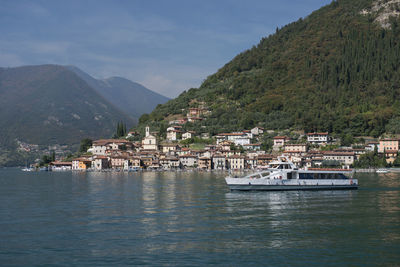 Scenic view of townscape by sea against mountains