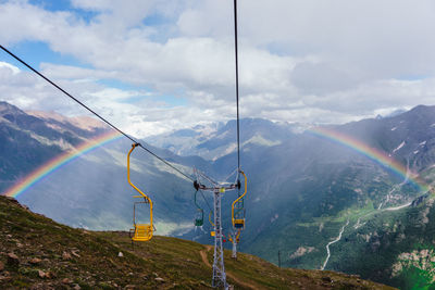 Scenic view of rainbow over mountains against sky