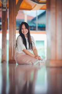 Portrait of a smiling young woman sitting outdoors