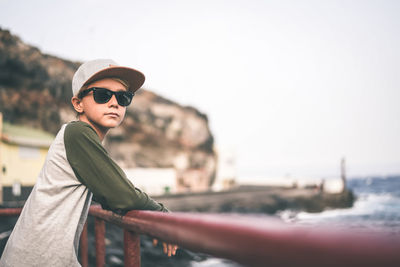 Portrait of young man wearing sunglasses against sky