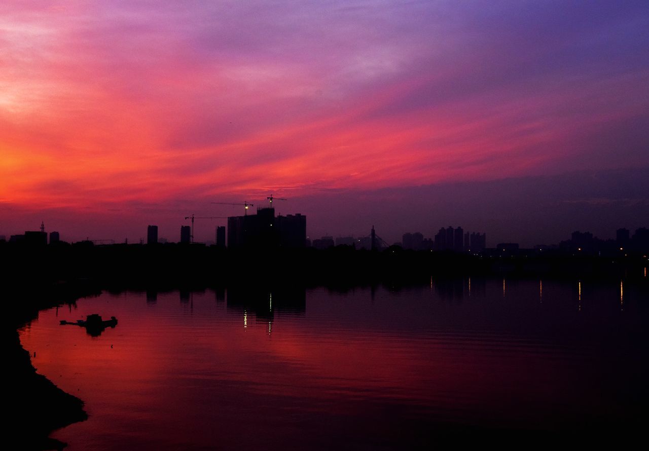 water, sky, sunset, reflection, building exterior, architecture, waterfront, orange color, cloud - sky, city, built structure, nature, beauty in nature, lake, silhouette, scenics - nature, building, no people, office building exterior, outdoors, skyscraper, cityscape