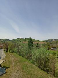 Road amidst field against sky