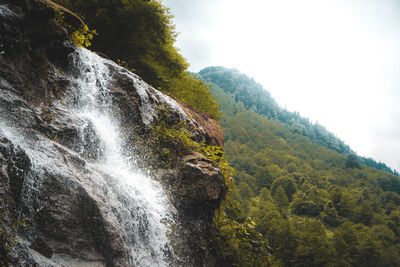 Scenic view of waterfall against sky