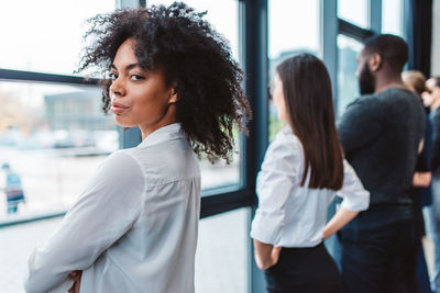 Portrait of young woman standing in city