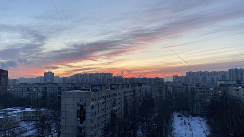 Buildings in city against sky during sunset