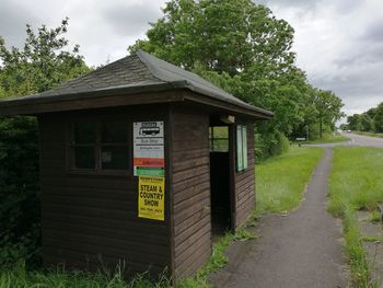 Information sign on field against sky