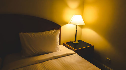 Illuminated electric lamp on bed