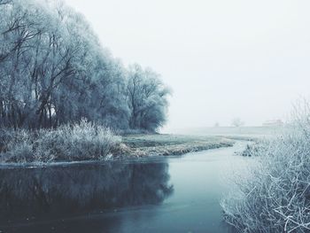 Scenic view of lake against clear sky during winter