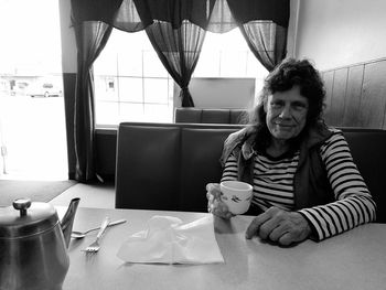 Portrait of woman having drink on table