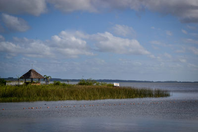 Houses by sea against sky