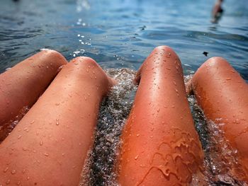 Low section of friends sitting in swimming pool