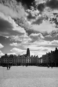 Buildings in city against cloudy sky