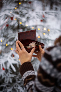 Midsection of woman holding christmas tree during winter