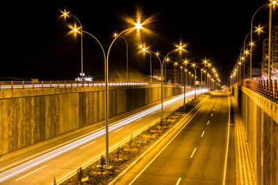 Light trails on road against sky at night