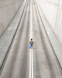 Rear view of woman walking on road