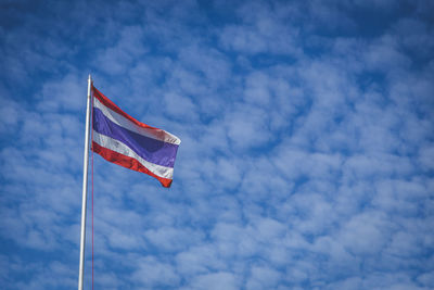 Low angle view of thailand flag waving against cloudy sky
