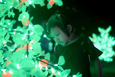 Full length of girl looking at illuminated light