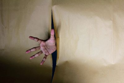 Close-up of hands against wall