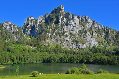 Scenic view of lake and mountains against clear sky