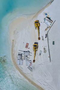 Maldives, aerial view of construction site at edge of sandy beach